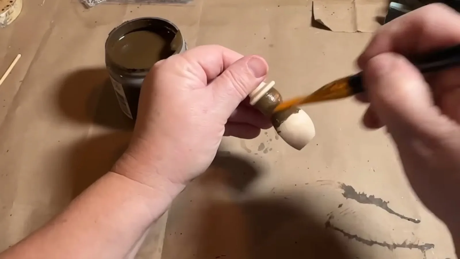 Applying antiquing wax to create a weathered finish on a wooden snowman
