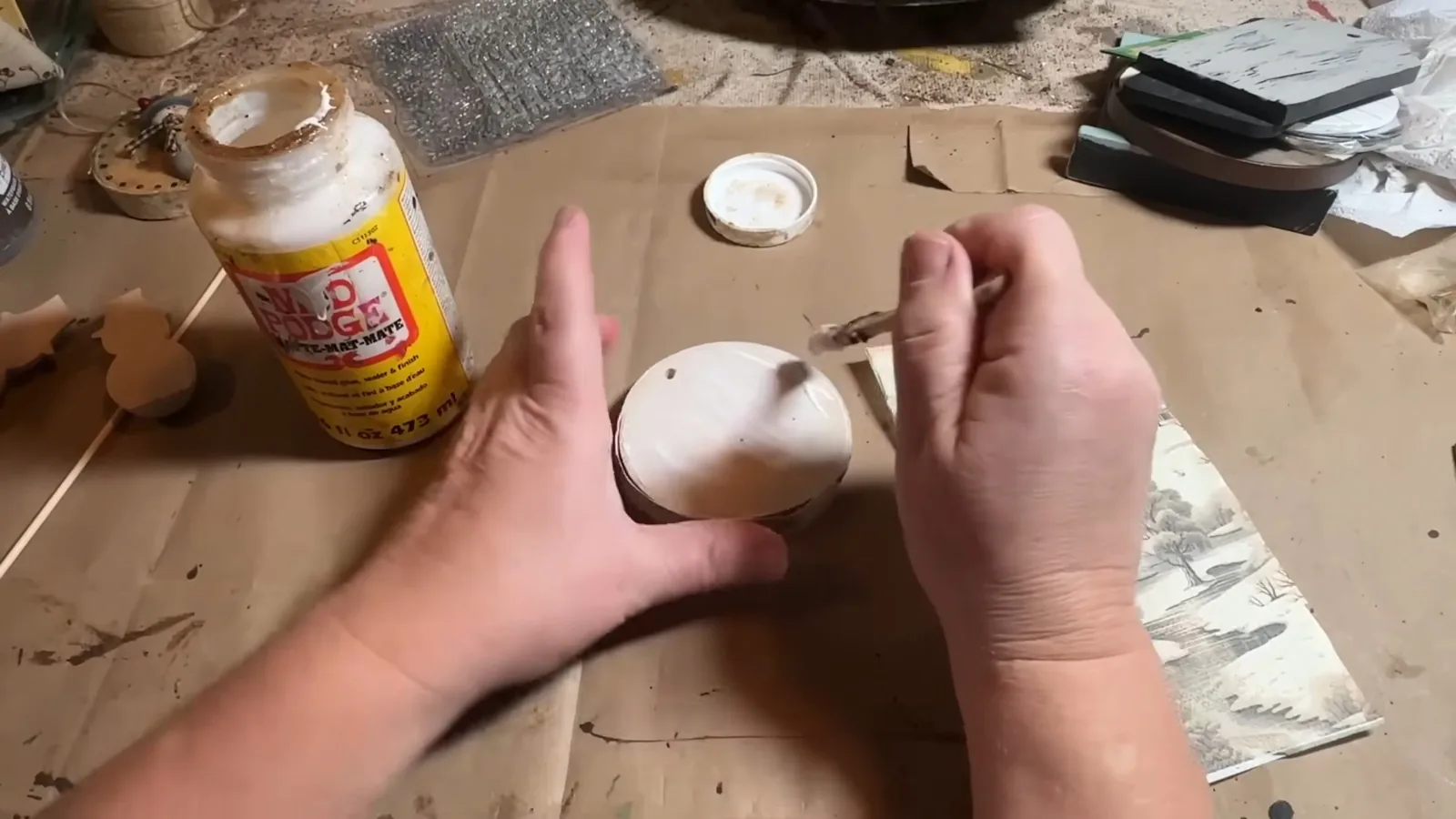 Applying decoupage medium to a wooden Christmas ornament blank