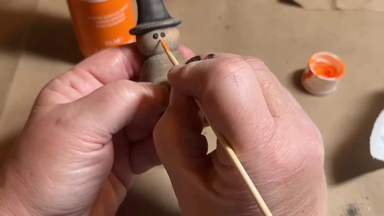 Hand-painted face details on a small primitive Christmas snowman